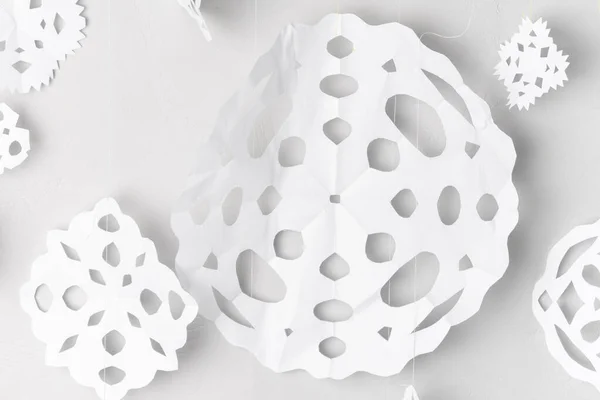 stock image white paper snowflakes garland on grey wall