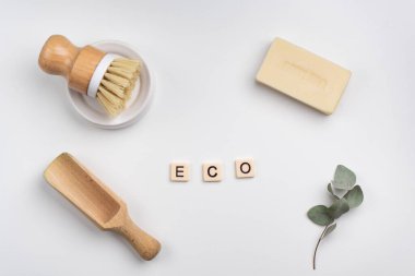 Sürdürülebilir yaşam tarzı konsepti bambu fırçası, ahşap kepçe ve sabun kalıbıyla yatıyordu. ECO kelimesi kiremit harflerle yazıldı  