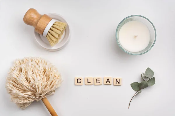 Sürdürülebilir yaşam tarzı konsepti bambu fırçası, toz fırçası ve mum ile yatıyordu. Kelime kiremit harflerle yazılmış.  