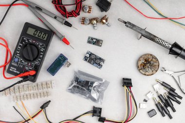 Gri arka planda farklı elektrikli aletlerin düzenlenmesi. çokölçer, dönüştürücü, adaptörler, ısı küçültücü vs..