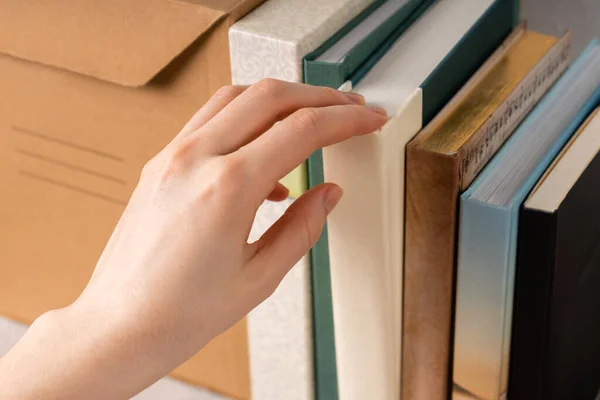 Kitaplıktan kitap çıkaran bir el. ev kitaplığı