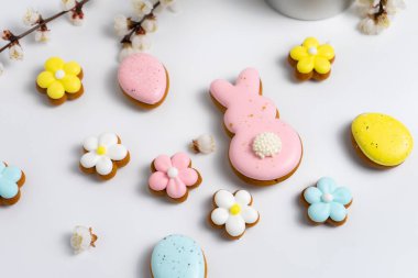 Beyaz arka planda Paskalya kurabiyeleri ve kiraz çiçekli dallar