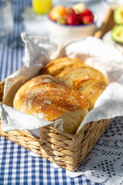 Gingham masa örtüsü üzerinde ekmek sepeti