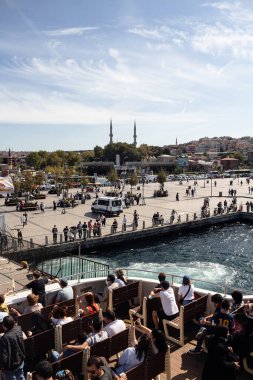İstanbul 'un Asya tarafındaki Uskudar meydanı ve Boğaz' daki gezi teknesindeki turistlerin görüntüsü. Güneşli bir yaz günü..