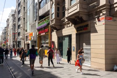 İstanbul 'da Istiklal Bulvarı' nda yürüyen insanların görüntüsü şehrin ana yaya bulvarı. 19. yüzyıl binaları, alışveriş zincirleri ve kafelerle dolu bir cadde. Güneşli bir yaz günü..