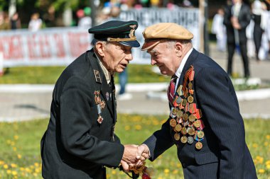 UKRAINE, Romny, May 9, 2013, Victory Day, May 9: Two veterans of the Second World War congratulate each other on the Victory Day.