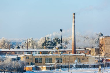 Fabrikanın dumanlı bacaları çevreyi kirletir. Kışın, şirketlerin bacasından duman çıkar..