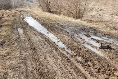 Yağmurdan sonra birikintileri olan toprak yol