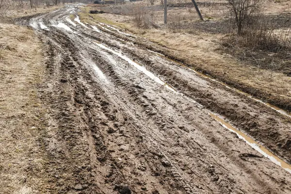 Bir sürü çamurlu su birikintisi olan kırsal toprak yol.