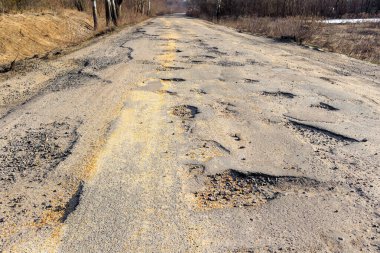 Kötü yol, asfalt çatlamış çukurlar ve büyük delikler. Yolun kötü durumda, tamire ihtiyacı var. Yola saçılmış tahıl