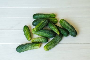 Beyaz ahşap arka planda sulu taze salatalıklar. Sebzeler.