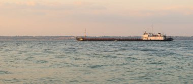 Karadeniz 'in sularında hareket eden siyah bir kargo gemisi. Büyük bir kargo gemisi bir deniz koyunda yol alıyor..