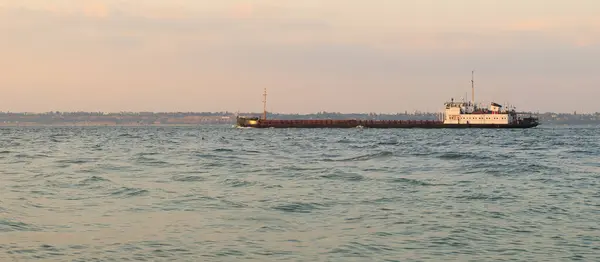 Karadeniz 'in sularında hareket eden siyah bir kargo gemisi. Büyük bir kargo gemisi bir deniz koyunda yol alıyor..