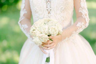 Beyaz elbiseli gelin bir buket çiçek tutuyor. Kapatın. Düğün portresi, yakın plan fotoğraf. Yaz düğünü