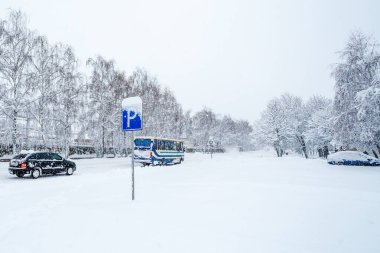 Yol işareti park ettiğini gösteriyor. Bir kış günü kar yağışı sırasında karlı bir caddede yol tabelası. Karla kaplı caddeye park ediyorum.