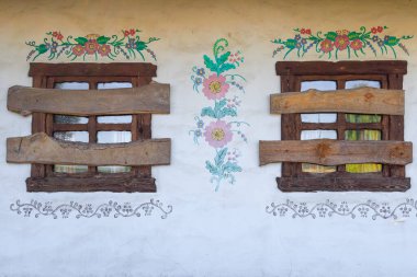 Evin pencereleri tahtayla kapatılmış. Pencereleri tahtayla kapatılmış terk edilmiş eski bir Ukrayna evi. 19. yüzyılın Ukrayna evi. Binanın ön cephesi bir köy evinin Ukrayna halk tarzında yapılmıştır.