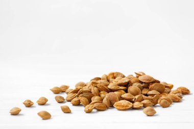 Kayısı çukurları arka planda yatar. Her kayısı taşının içinde çekirdek şeklinde küçük bir hazine var. Mineraller, proteinler bakımından zengindirler ve amigdalin adı verilen bir madde içerirler.