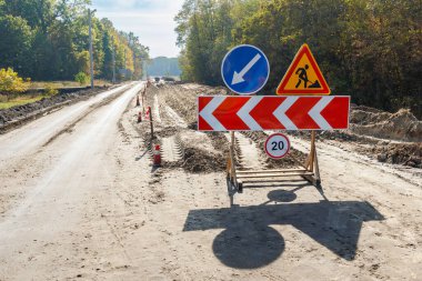 Üzerinde çalışıyorum. Roadworks, yol işaretleri. Erkekler işte. Bazı işaretler tabela için kentsel sokak üzerinde çalışıyorum. Engelleri ve yol işaretleri. Siluet bir işçinin iş yerinde. Sağ ok.