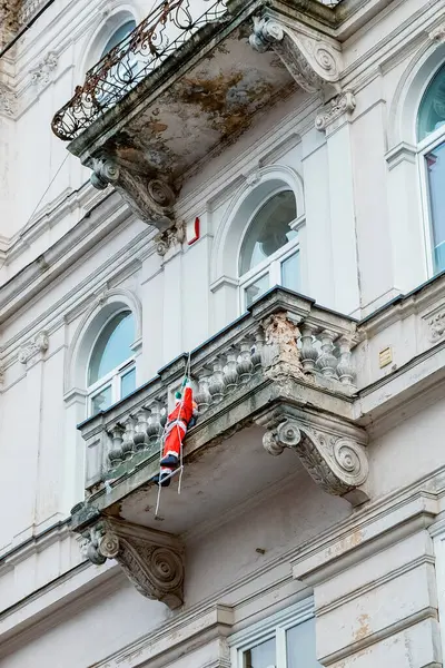 Oyuncak bir Noel Baba eski bir binanın balkonunda merdivene tırmanır ve Noel süsleri ortaya çıkar. Bir Avrupa şehrinin sokaklarında kış tatili için Noel dekorasyonu.