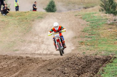 Ukrayna, Romny, 5-6 Eylül 2020: Motokros yarışçısı arka planda seyircilerle toprak pistte yarışıyor. Dinamik spor görüntüleri hız ve aksiyon gösteriyor. Ukrayna Motokros Şampiyonası