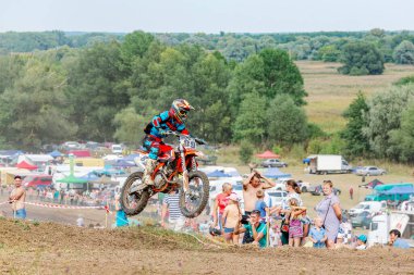 Ukrayna, Romny, 5-6 Eylül 2020: Motokros yarışçısı arka planda seyircilerle toprak pistte yarışıyor. Dinamik spor görüntüleri hız ve aksiyon gösteriyor. Ukrayna Motokros Şampiyonası