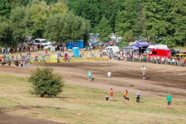 Ukrayna, Romny, 5-6 Eylül 2020: Motokros yarışçıları bir geri sayım işareti tutan bir yetkiliyle başlangıç kapısında sıraya girdiler. Toprak yolda açık hava spor müsabakası. Ukrayna Motokros Şampiyonası