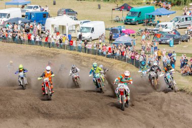 Ukrayna, Romny, 5-6 Eylül 2020: Motokros yarışçıları arka planda seyircilerle toprak pistte yarışıyorlar. Ukrayna Motokros Şampiyonası