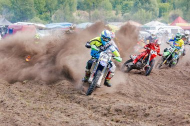 Romny, Ukrayna, 14 Mayıs 2017: Motokros yarışmasının dinamik anı motorsiklet yarışçılarının toz ve çamurla kaplı bir pistte yarışmaları.