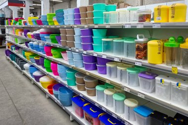 Mağaza raflarında çeşitli renklerde plastik kaplar, kaseler ve depolama kutuları, organizasyon ve mutfak depolama çözümleri sunar.