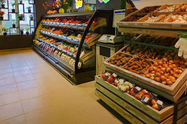 İyi organize edilmiş bir markette taze sebzeler ve soğanlar, patatesler, havuçlar, domatesler ve sebzeler de dahil olmak üzere meyveler sergileniyor..