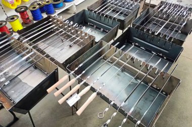 Bir hırdavatçıda çelik ızgaralar üzerine yerleştirilmiş çeşitli metal şişler. Barbekü meraklıları için ideal.