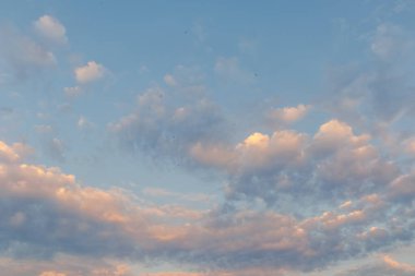 Akşam bulutları altın ve pembe ışıkla yıkanır, sakin ve manzaralı bir gökyüzü oluşturur. Arka plan ve tasarımlar için mükemmeldir.