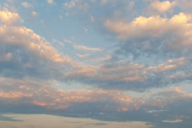 Yumuşak bulutlar, alacakaranlık gökyüzündeki günbatımını yansıtır. Huzurlu ve rahatlatıcı bir gökyüzü yaratır.