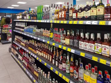 Ukrayna, Romny, 23.08.2025: Viski, votka, rom ve diğer alkollü içecekler süpermarket raflarında görünür fiyat etiketleriyle güzelce düzenlenmiştir..