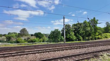 Kuzeydeki Grand Central sınıfı 180 Adelante ekspres yolcu treni Londra 'nın kuzeyindeki Potter' s Bar 'da güneye giden bir LNER Azuma servisinden geçiyor..