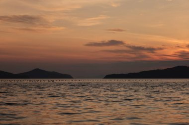 Güzel ve dramatik bir gökyüzü, gün batımında deniz üzerinde bulutlar.