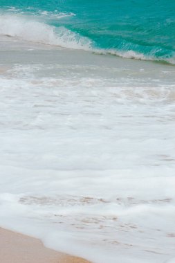 Mavi gökyüzü ve beyaz köpükle güzel bir sahil..