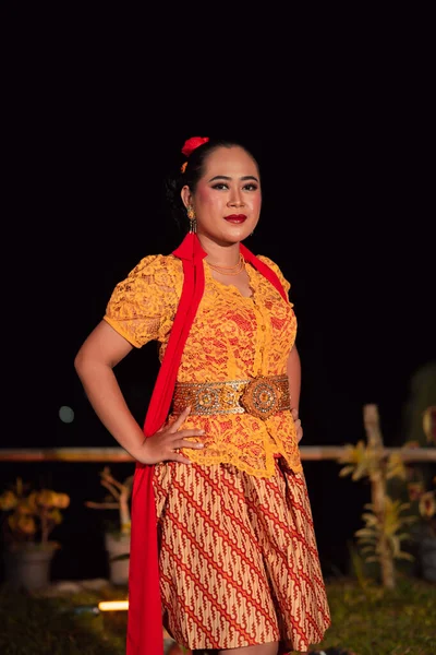 祭りの中で舞踊を踊るときに ケバヤと呼ばれるオレンジ色の伝統舞踊の衣装を着た美しいインドネシアの女性 — ストック写真