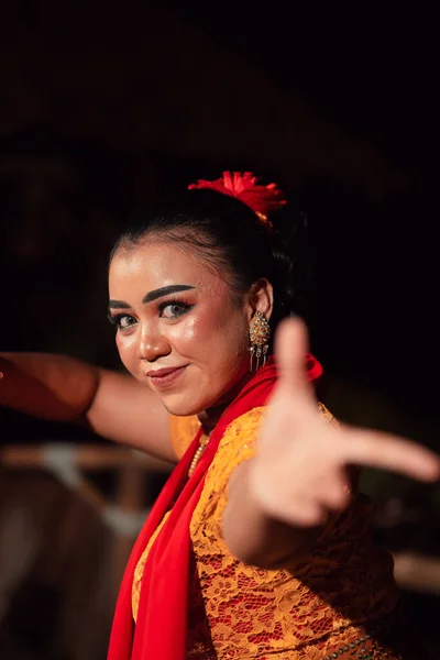 夜の祭りでは オレンジ色の衣装で伝統舞踊を踊りながら化粧をしているインドネシア人女性の美しい顔 — ストック写真