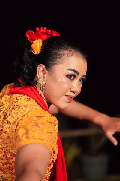 夜の祭りでは オレンジ色の衣装で伝統舞踊を踊りながら化粧をしているインドネシア人女性の美しい顔 — ストック写真