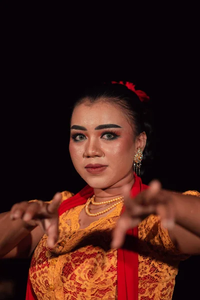 夜のダンスフェスティバルでオレンジ色のドレスを着ている間 化粧をしたインドネシアの女性からの鋭い目 — ストック写真