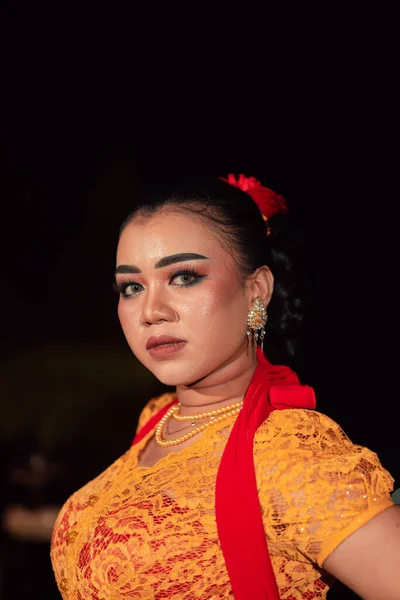 在晚上的舞蹈节上 身穿橙色衣服的印尼女人的锐利的眼神 — 图库照片