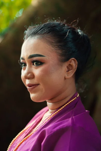Indonezyjka Uśmiechnięta Tradycyjnej Fioletowej Sukience Makijażem Złotą Biżuterią Przed Wielkim — Zdjęcie stockowe