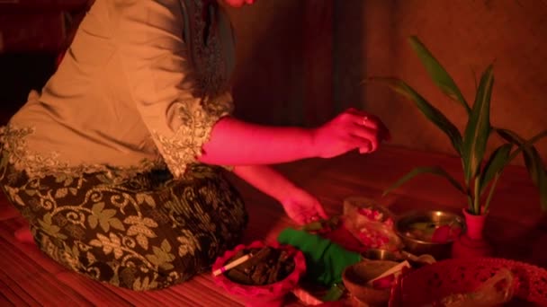 印度尼西亚妇女在夜间在屋里祷告之前 先以宗教仪式的形式为神预备祭品 — 图库视频影像