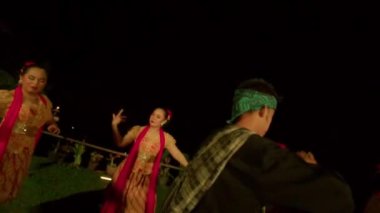 Balili kadınlar ayini dansla kutlarken, bir adam da festivalin içinde sahnede dans eden dansçı arasında gökyüzüne para saçıyor.
