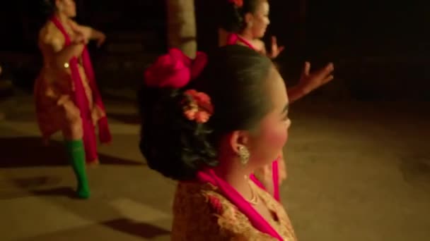 インドネシアの人々は 伝統舞踊祭で体内の暖かい照明とオレンジのドレスで幸せに一緒に踊ります — ストック動画