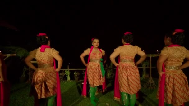 一群爪哇舞者站在一起 然后在舞台上跳舞 晚上穿着橙色衣服 点着温暖的灯光 — 图库视频影像