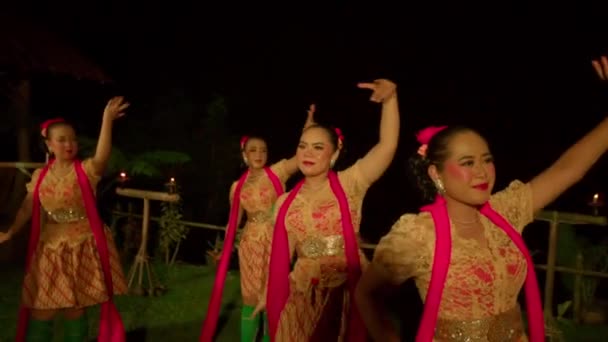 バリの人々は村の中のステージで緑の靴下と赤いスカーフを身に着けている間 幸せな顔で伝統的なダンス大会で一緒に踊ります — ストック動画