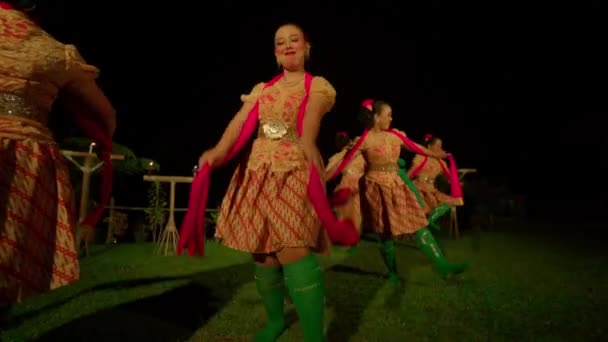 バリの人々は村の中のステージで緑の靴下と赤いスカーフを身に着けている間 幸せな顔で伝統的なダンス大会で一緒に踊ります — ストック動画
