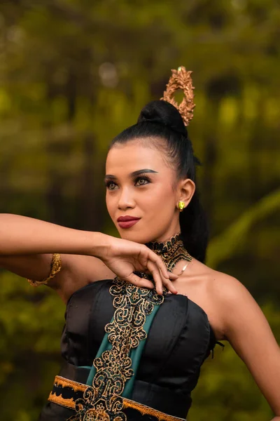 The fierce face of an Indonesian woman wearing makeup on her face and a black costume after a dance performance at the festival